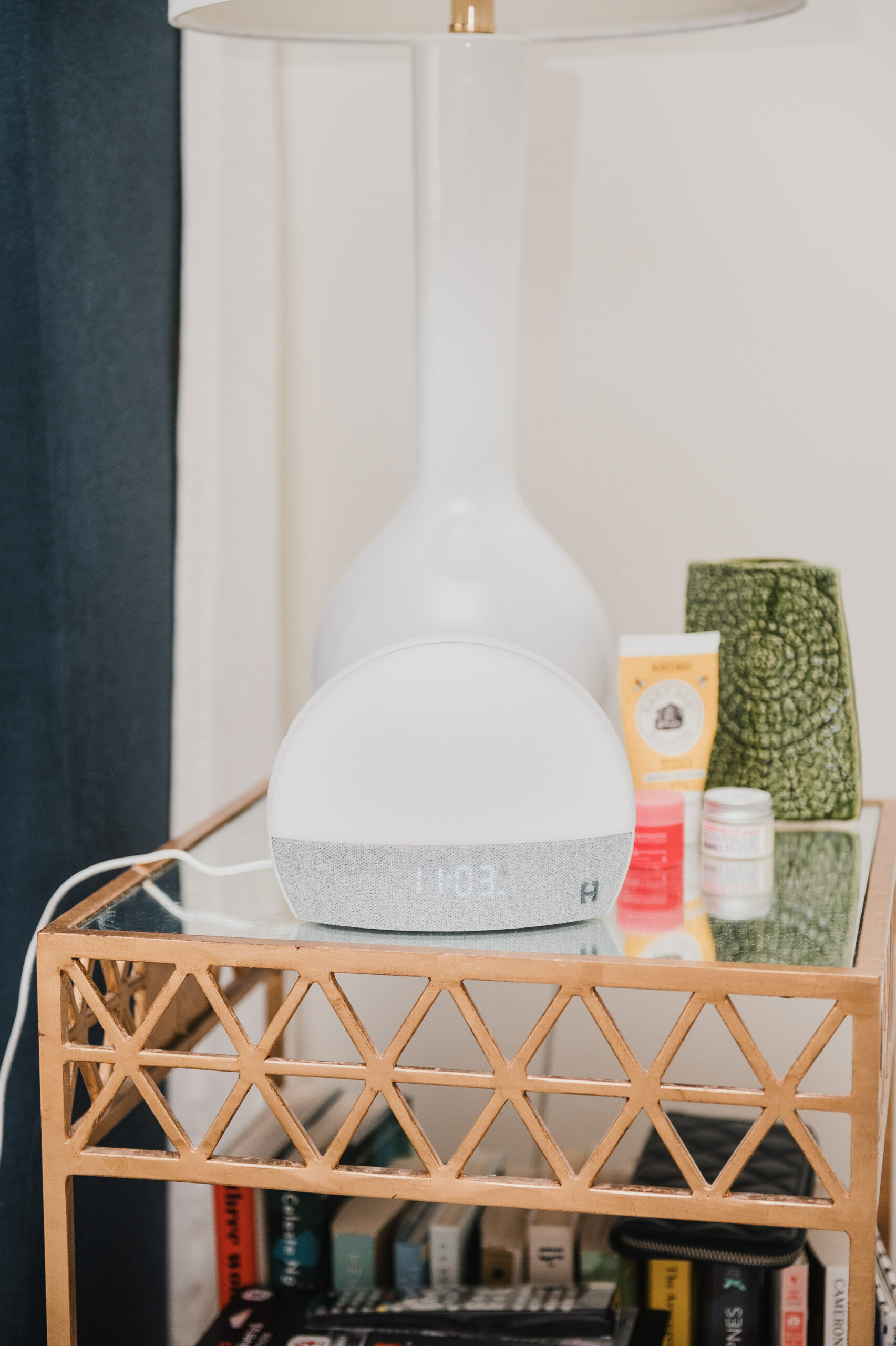 bedside table bedside table with Hatch Restore, lamp, skincare products, and books